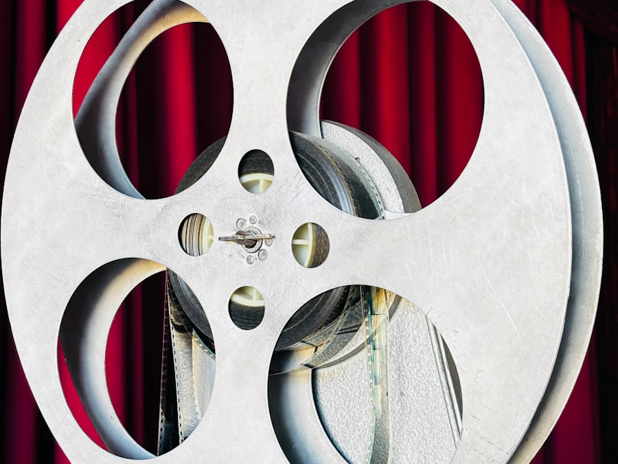 A vintage film projector and reel in front of a red curtain