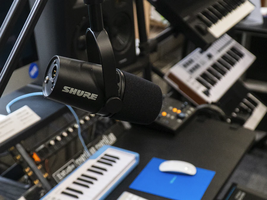 A recording studio with a microphone, a keyboard and monitors